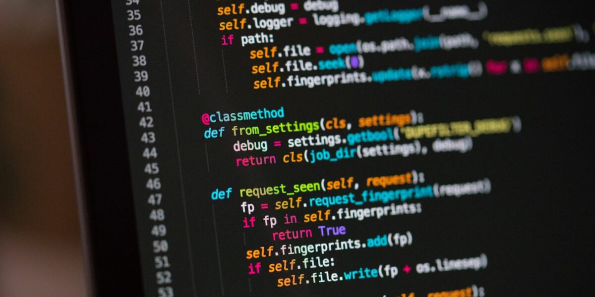 Tela de computador com código em fundo escuro, ilustrando a revisão de software.
