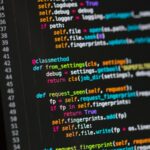 Tela de computador com código em fundo escuro, ilustrando a revisão de software.