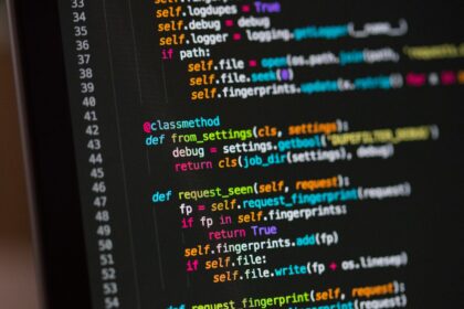 Tela de computador com código em fundo escuro, ilustrando a revisão de software.